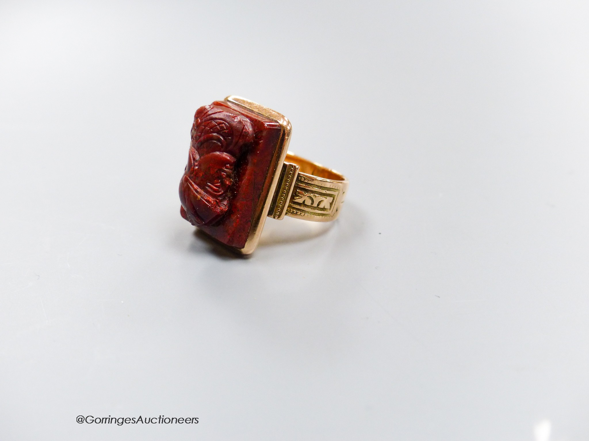 A 19th century yellow metal (stamped 14) and jasper? cameo ring, carve with the bust of a soldier to dexter, size P, gross 11.7 grams (a.f.).